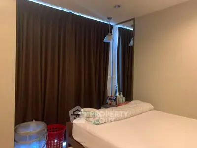 Cozy bedroom with large window and modern decor, perfect for relaxation.