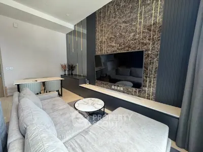 Luxurious modern living room with elegant marble accent wall and plush gray sofa