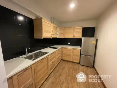 Modern kitchen with wooden cabinets and sleek black backsplash