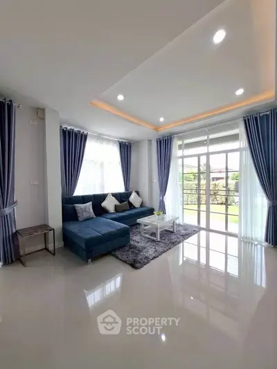 Spacious modern living room with elegant blue sofa and large windows