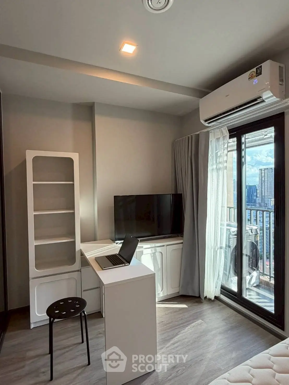 Modern living room with balcony view, featuring sleek furniture and abundant natural light.