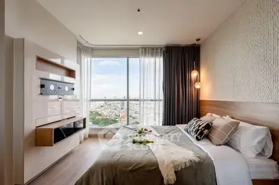 Modern bedroom with large window offering stunning city view and elegant decor.