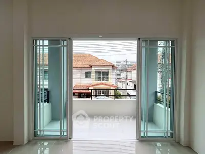 Spacious balcony with sliding glass doors offering a view of suburban houses.
