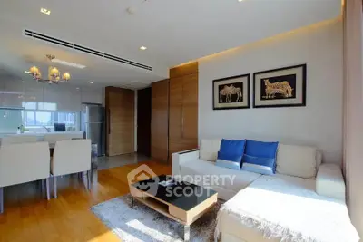 Modern living room with elegant decor and dining area, featuring wooden flooring and stylish lighting.