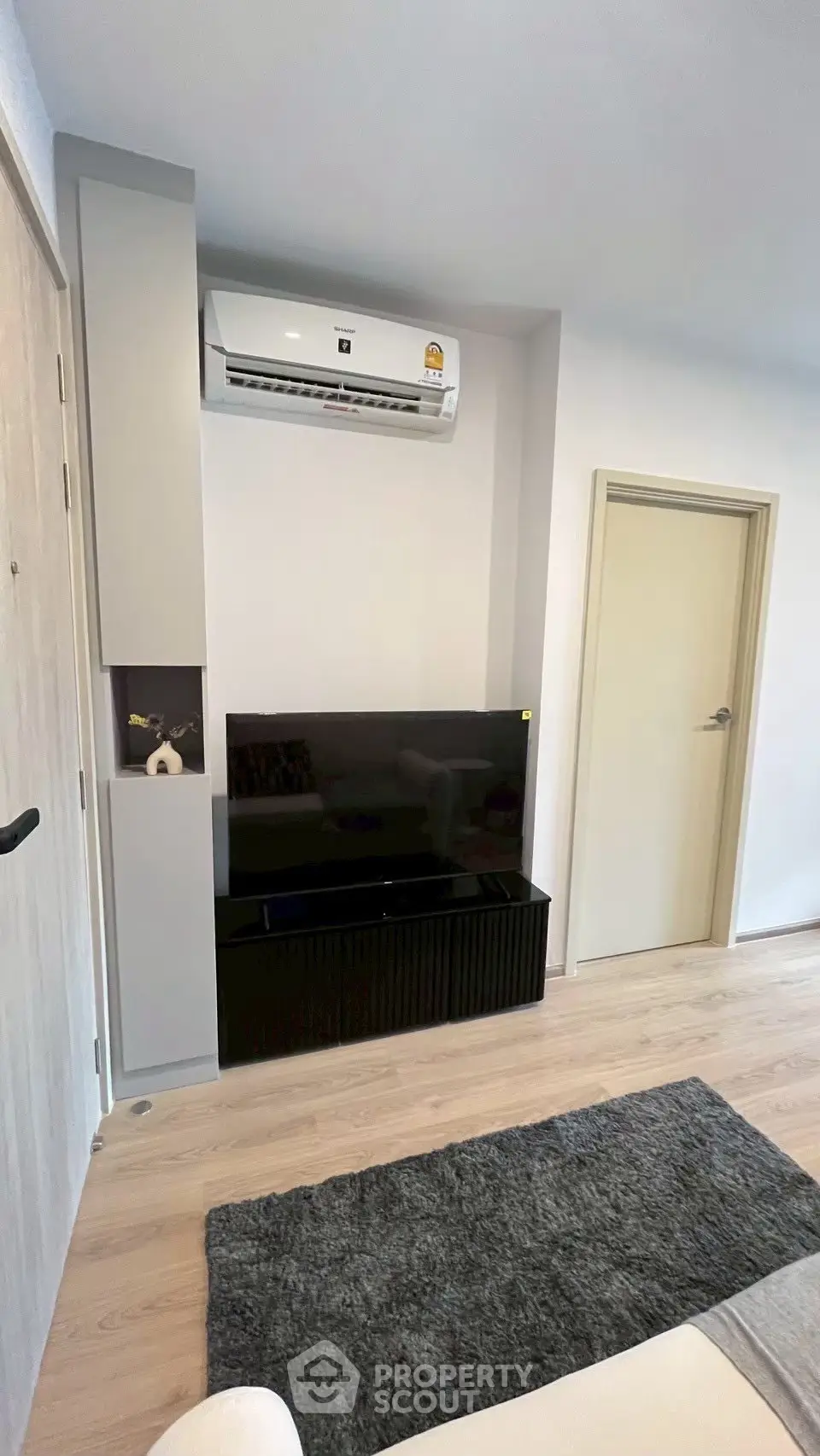 Modern living room with sleek TV setup and air conditioning unit