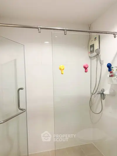 Modern bathroom with glass shower and colorful wall hooks