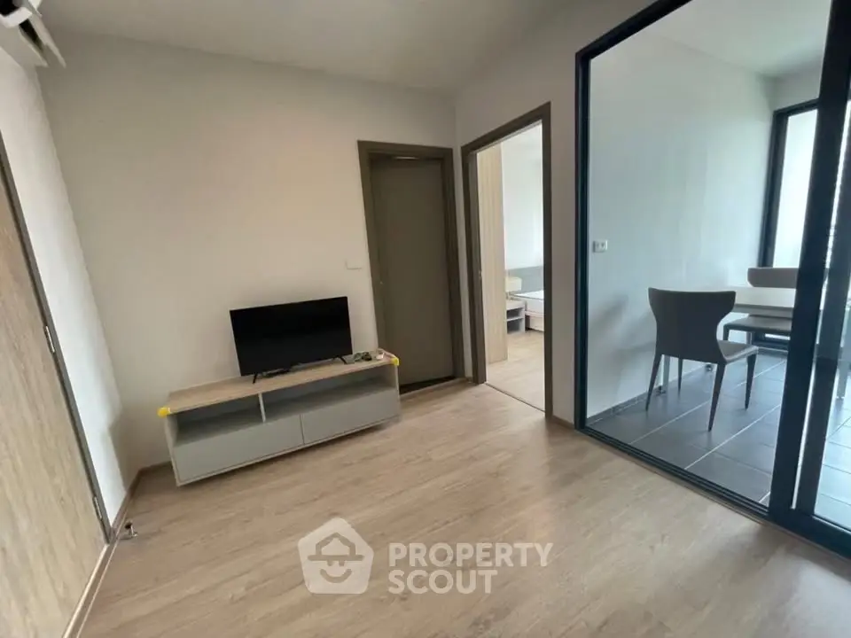 Modern apartment interior with sleek flooring and minimalist furniture, featuring a cozy living area and dining space.