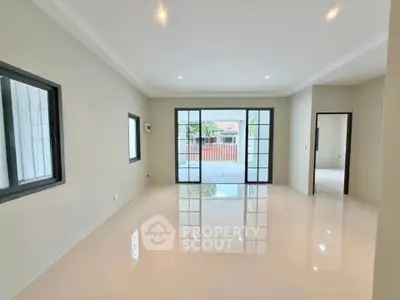 Spacious modern living room with large windows and glossy tiled floor.