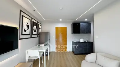 Modern living room with sleek kitchen and stylish decor in a contemporary apartment.