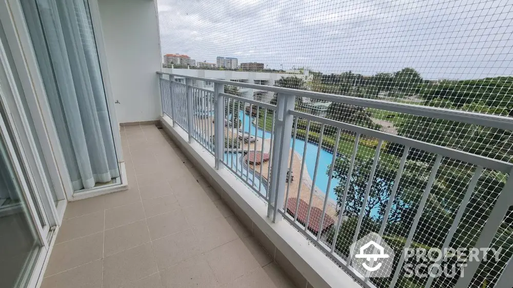 Spacious balcony with pool view in modern apartment complex