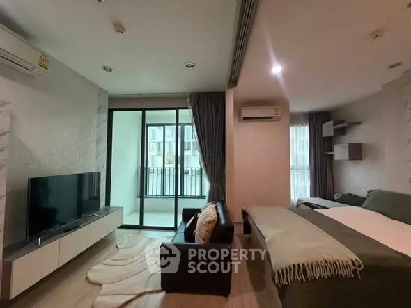 Modern studio apartment with cozy living area and balcony view