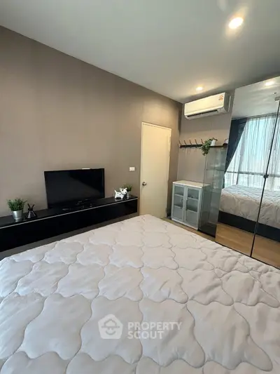 Modern bedroom with mirrored wardrobe and air conditioning in stylish apartment.