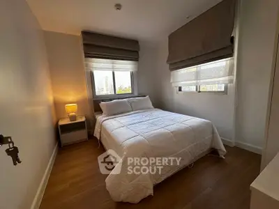 Cozy bedroom with large windows and modern decor in a city apartment