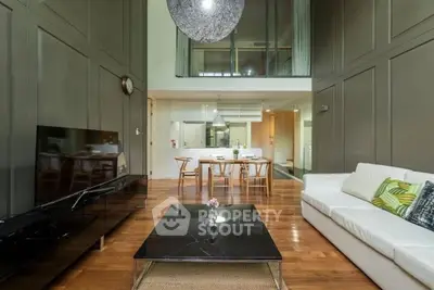Spacious modern living room with high ceilings, elegant decor, and open dining area, perfect for entertaining.