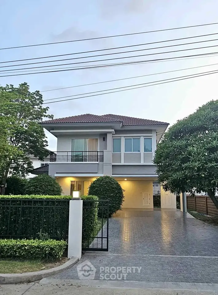 Charming two-story house with spacious driveway and lush greenery, perfect for family living.