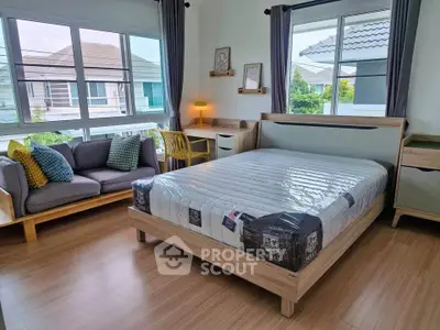 Spacious bedroom with large windows, modern furniture, and natural light in a stylish home.