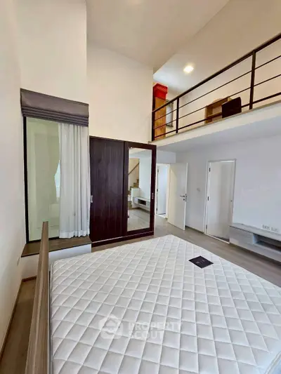 Spacious modern bedroom with loft and sleek design, featuring high ceilings and elegant finishes.