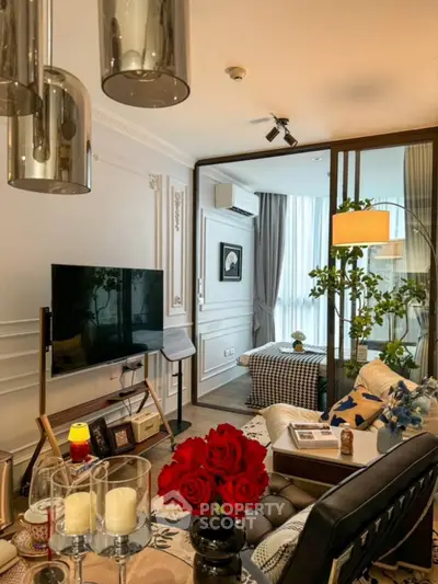 Chic living room with modern decor, large TV, and elegant lighting.