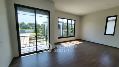 Spacious empty room with large windows and balcony access, perfect for customization.