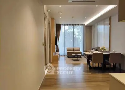 Modern open-plan living and dining area with stylish furniture and large windows.