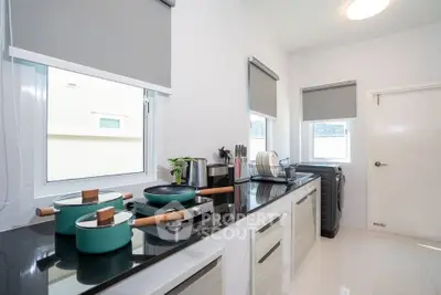 Modern kitchen with sleek countertops and appliances, featuring a bright and airy design.