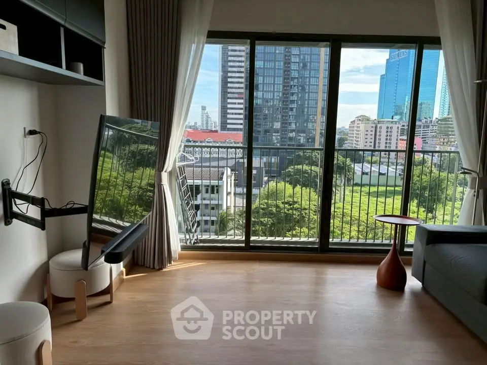 Modern living room with large window offering stunning city view and natural light.