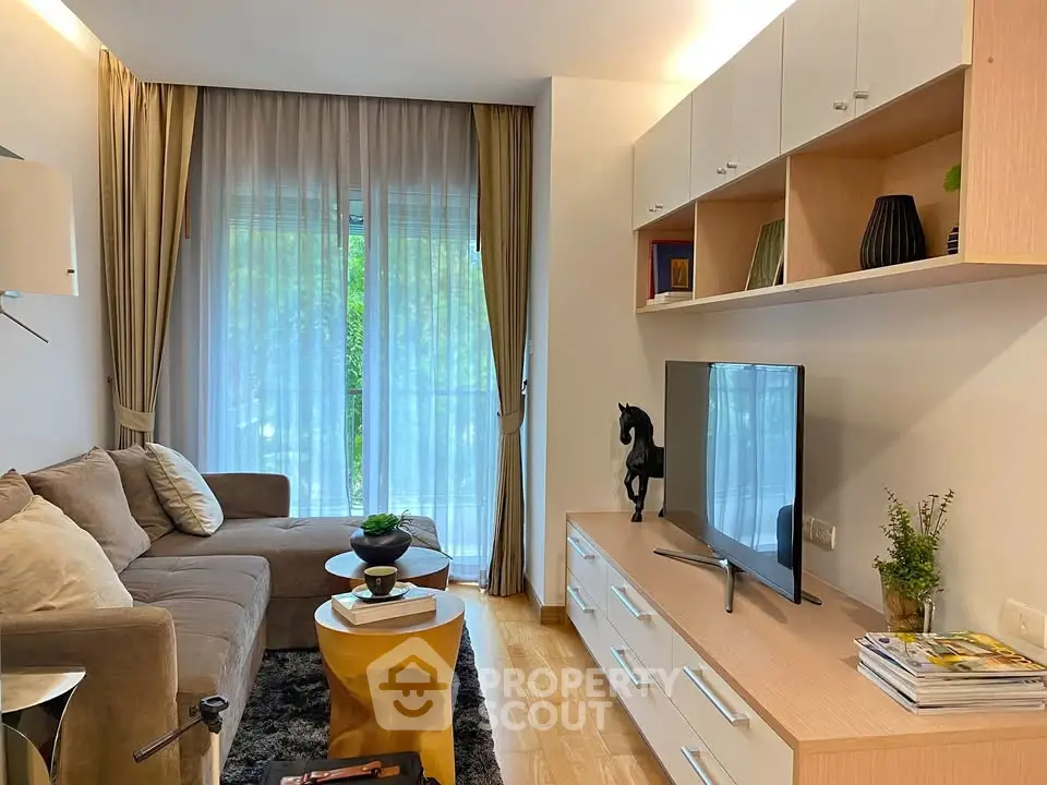 Stylish living room with modern decor and large window offering natural light.