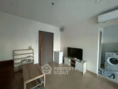 Cozy living room with modern furniture and in-unit laundry setup.