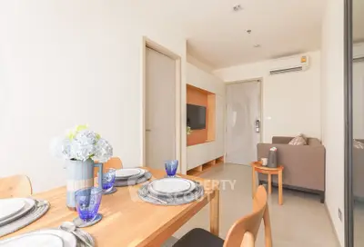 Modern dining area with elegant table setting and cozy living room in open-plan apartment.