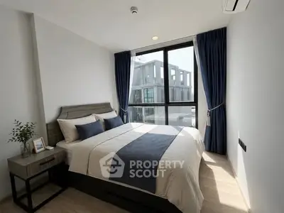 Modern bedroom with large window and stylish decor in a contemporary apartment.