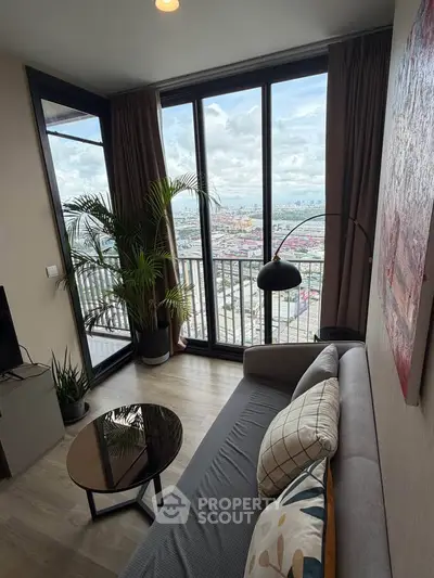Stylish living room with floor-to-ceiling windows offering stunning city views, modern decor, and cozy seating.
