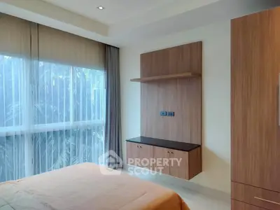 Modern bedroom with large window and stylish wooden cabinetry