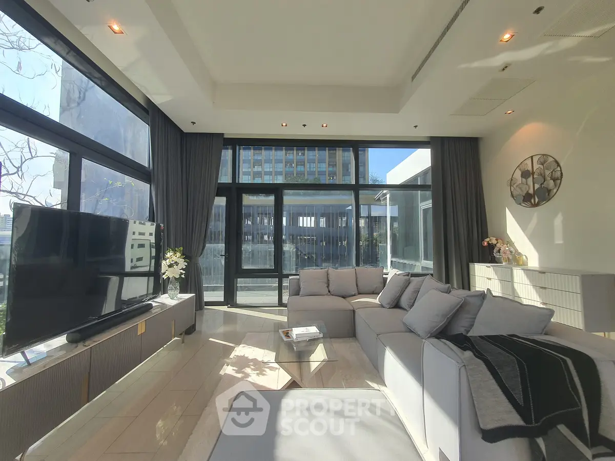 Luxurious modern living room with large windows and elegant decor in a high-rise apartment.