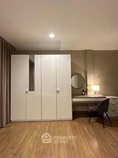 Modern bedroom with sleek wardrobe and stylish desk setup, perfect for a cozy and functional living space.