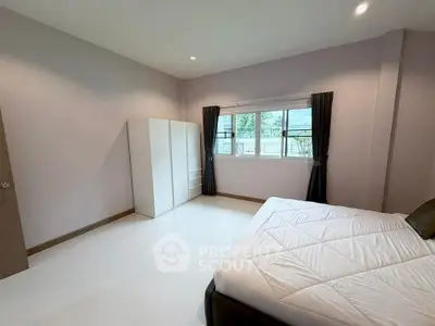 Spacious bedroom with large window and modern decor