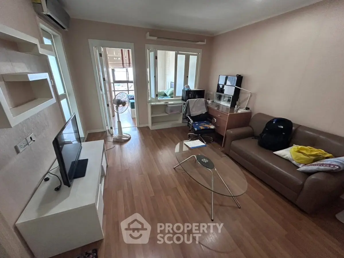 Spacious living room with modern furniture and natural light, perfect for relaxation and entertainment.