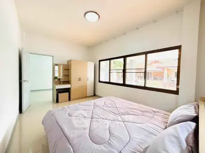 Bright and airy bedroom with large windows and modern furnishings in a cozy home.