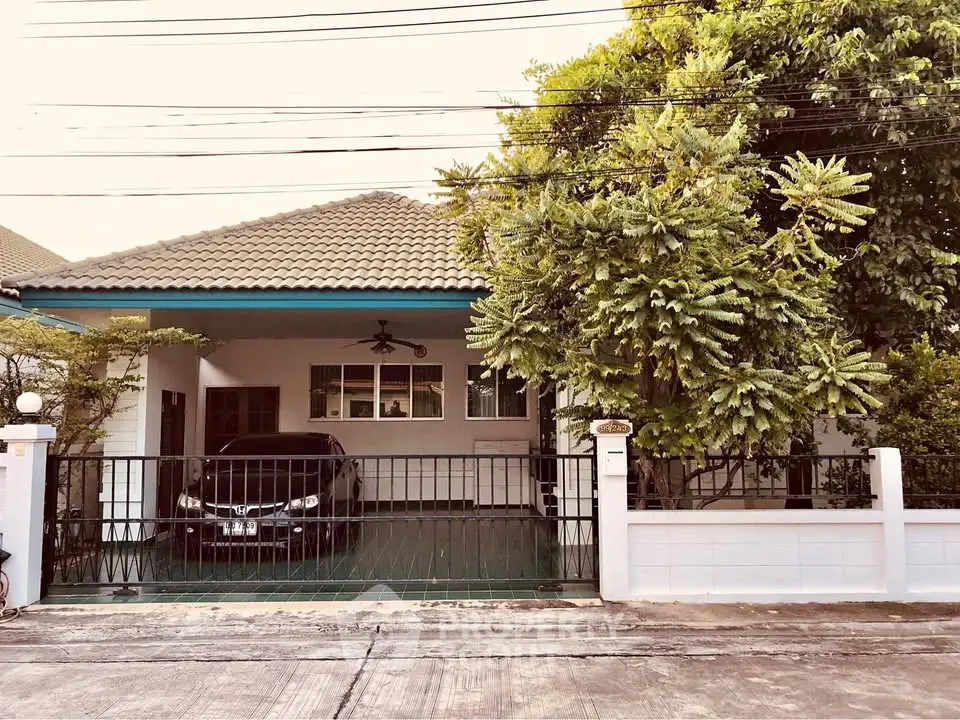 Charming single-story house with carport and lush greenery in a serene neighborhood.