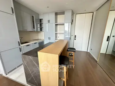 Modern kitchen with sleek cabinetry and breakfast bar in stylish apartment.