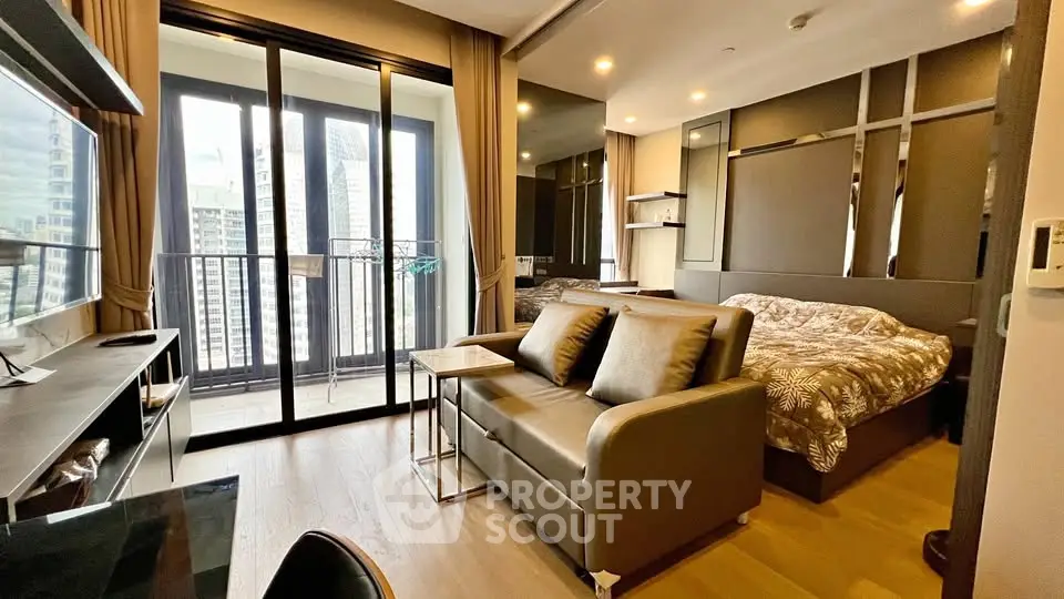 Modern studio apartment with balcony and city view, featuring stylish furniture and open layout.