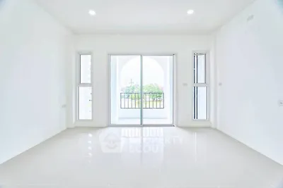 Spacious and bright living room with large windows and balcony access, perfect for modern living.