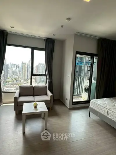 Modern apartment with city view, featuring a cozy living area and balcony access.