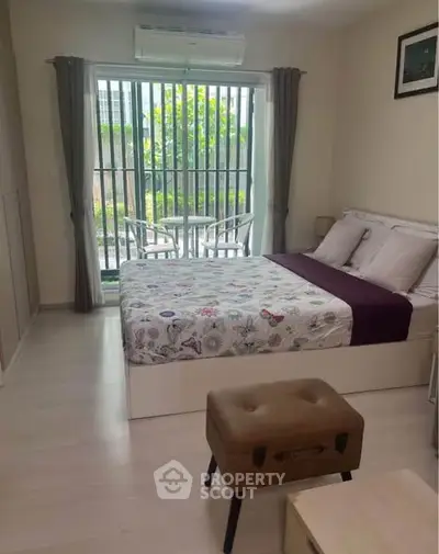 Cozy bedroom with modern decor and garden view, featuring a comfortable bed and stylish seating area.