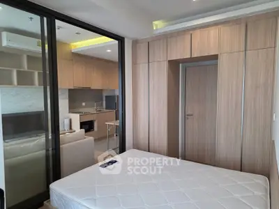 Modern studio apartment with open layout and built-in wooden cabinetry.