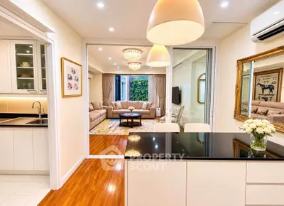Luxurious open-plan kitchen and living room with elegant decor and modern lighting.