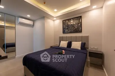 Modern bedroom with stylish decor and ambient lighting, featuring a comfortable bed and mirrored wardrobe.