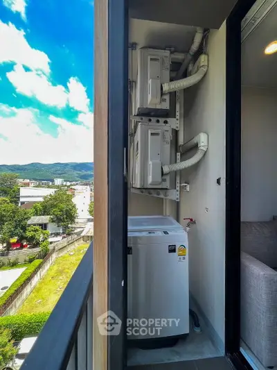Compact balcony with washing machine and scenic city view