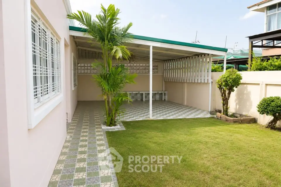 Charming home exterior with lush garden and covered patio, perfect for outdoor relaxation.