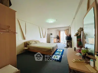 Spacious bedroom with cozy decor and natural light, featuring a comfortable bed and modern amenities.