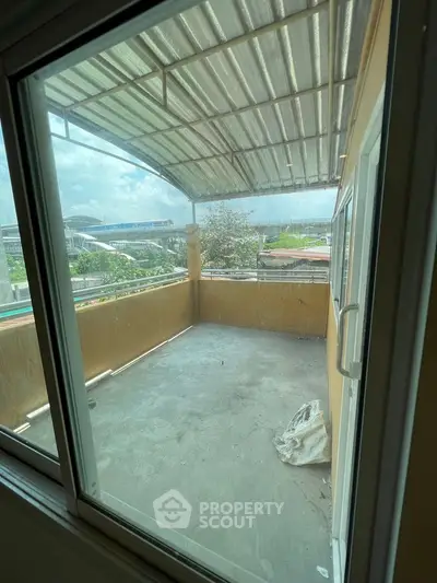 Spacious balcony with metal roof and scenic view, ideal for outdoor relaxation.